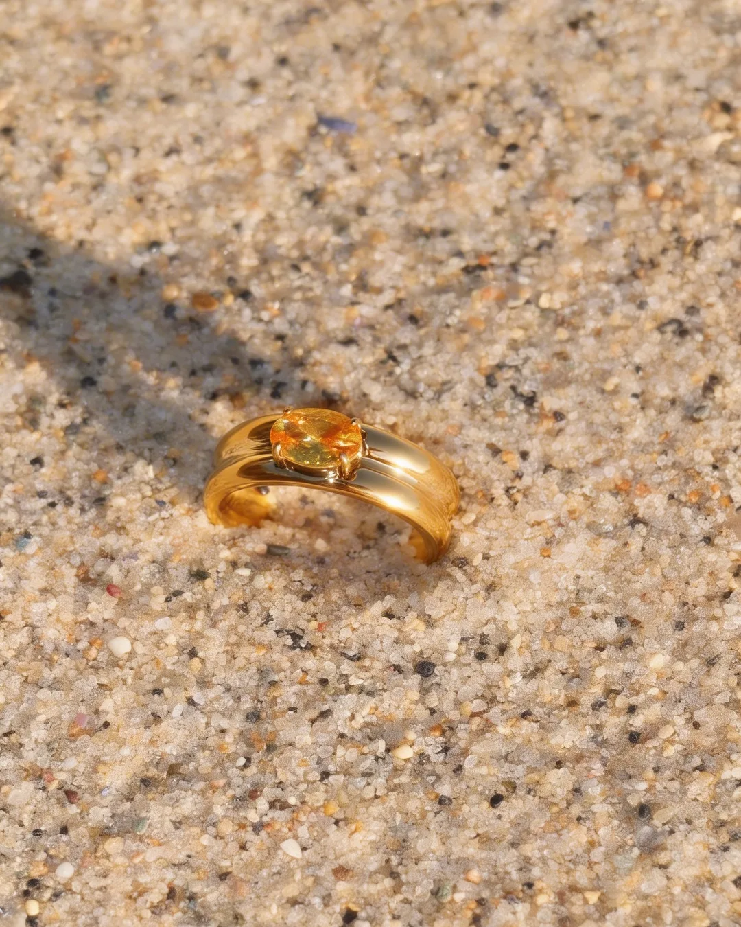 A gold ring resting in sand